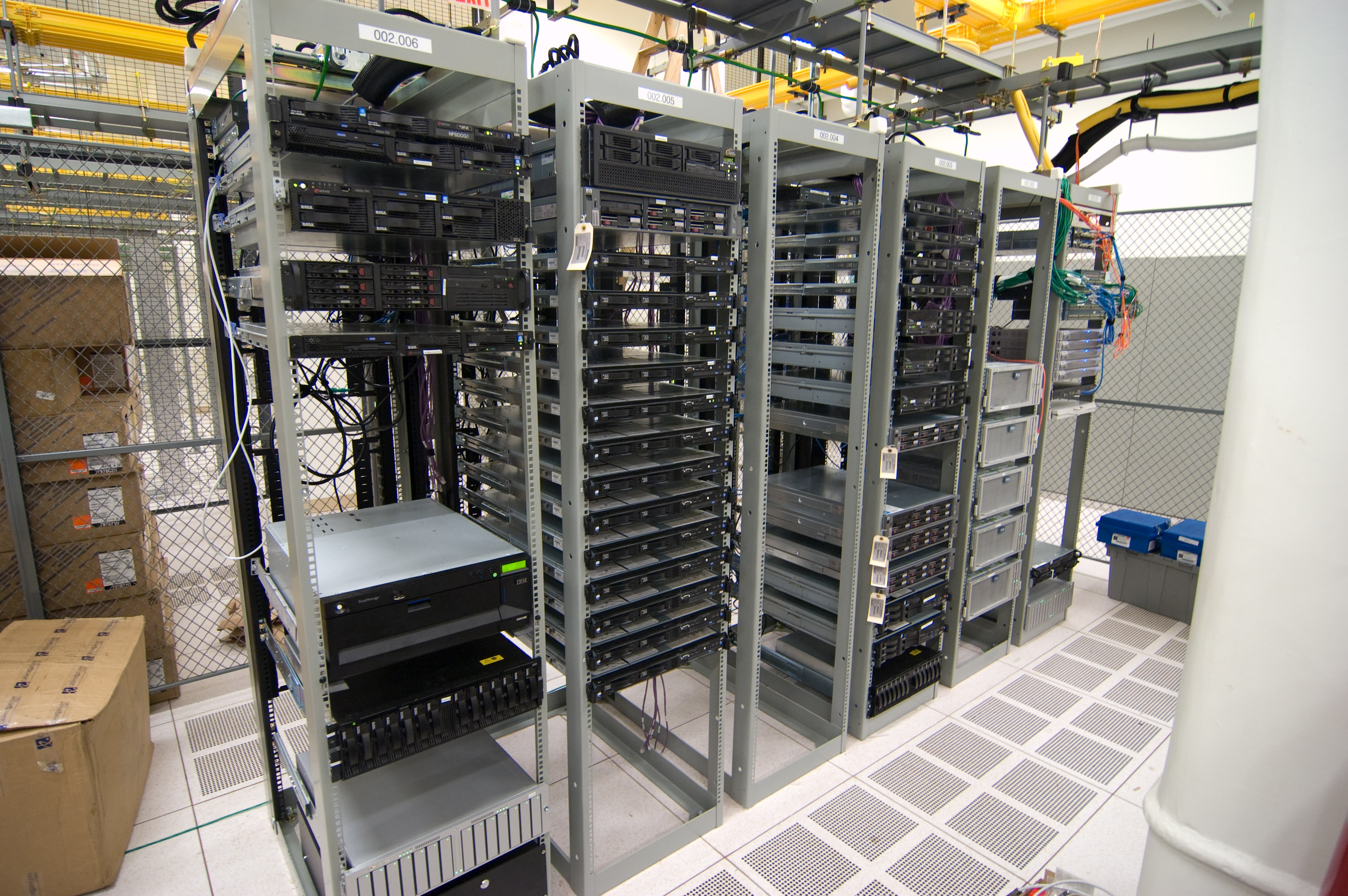 Rows of server racks and overhead cabling in a data center